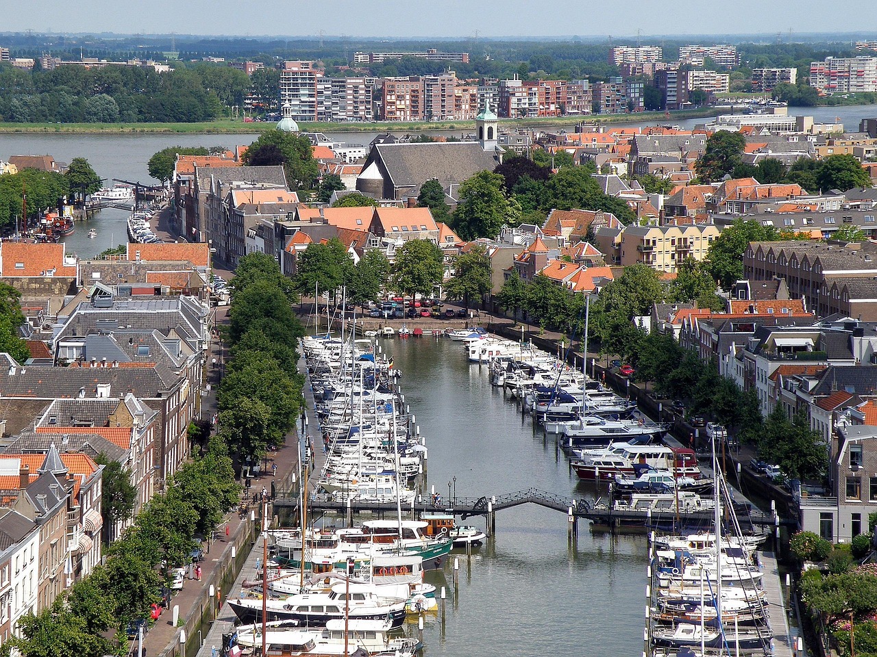 Luchtfoto van de historische haven van Dordrecht met oude panden, kades en afgemeerde boten; de binnenstad staat op een mengsel van rivierklei, veen en houten palen