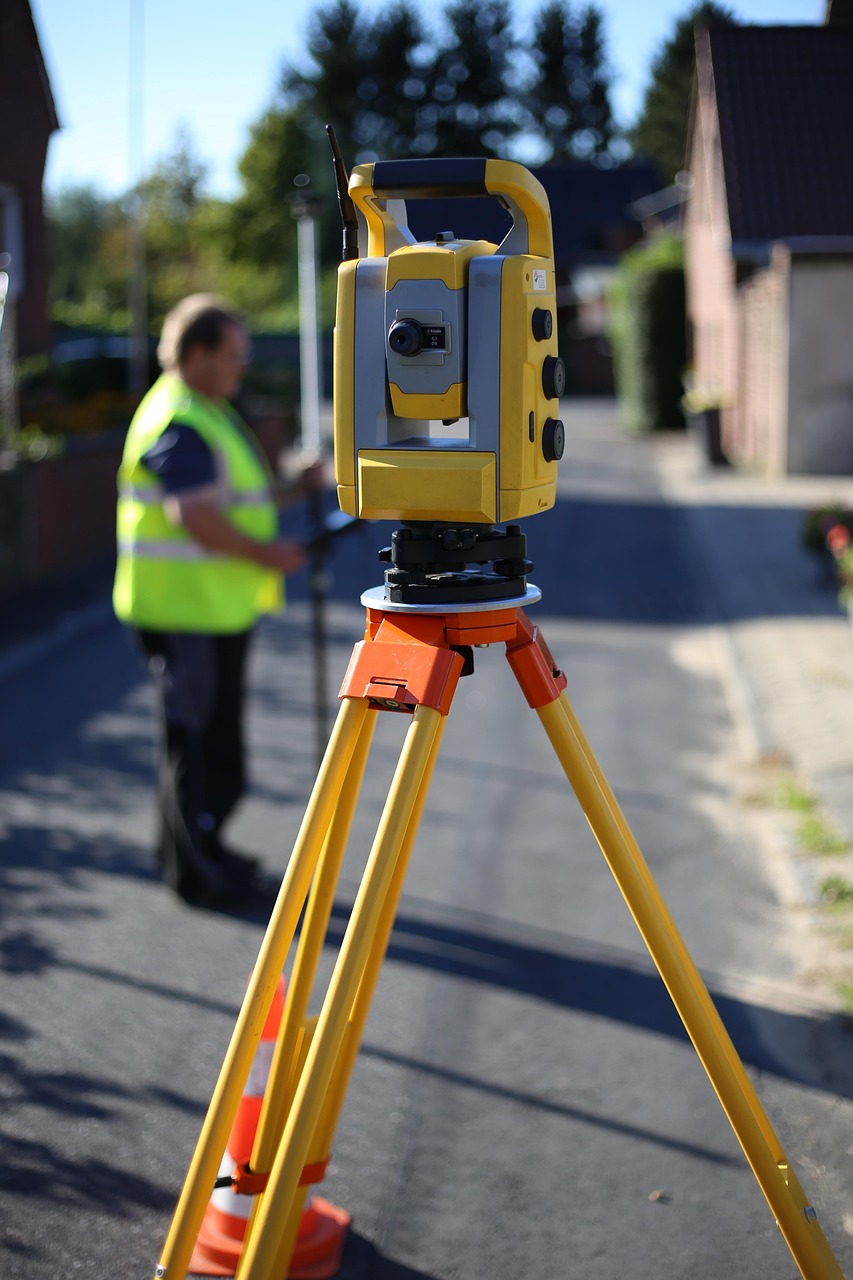 Landmeter met meetinstrument op statief voor een woning in de straat