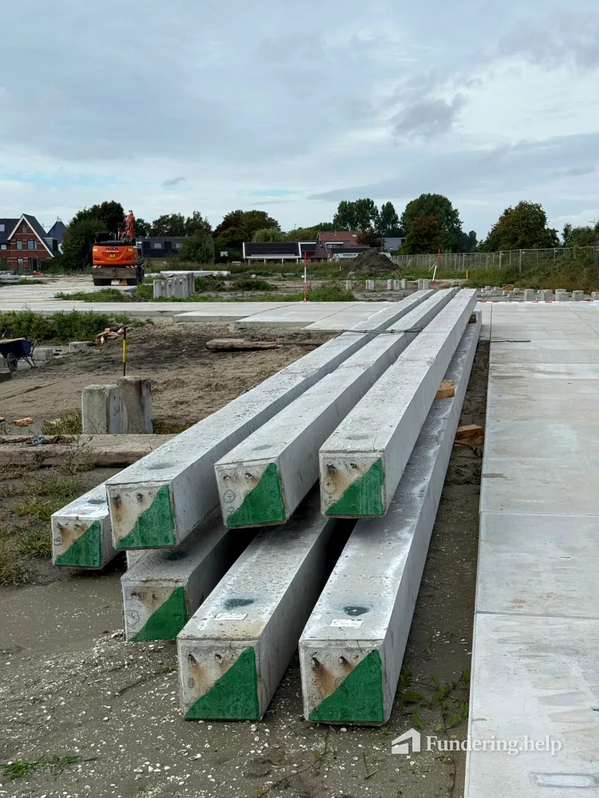 Lange prefab betonnen heipalen met vierkante doorsnede op een bouwplaats