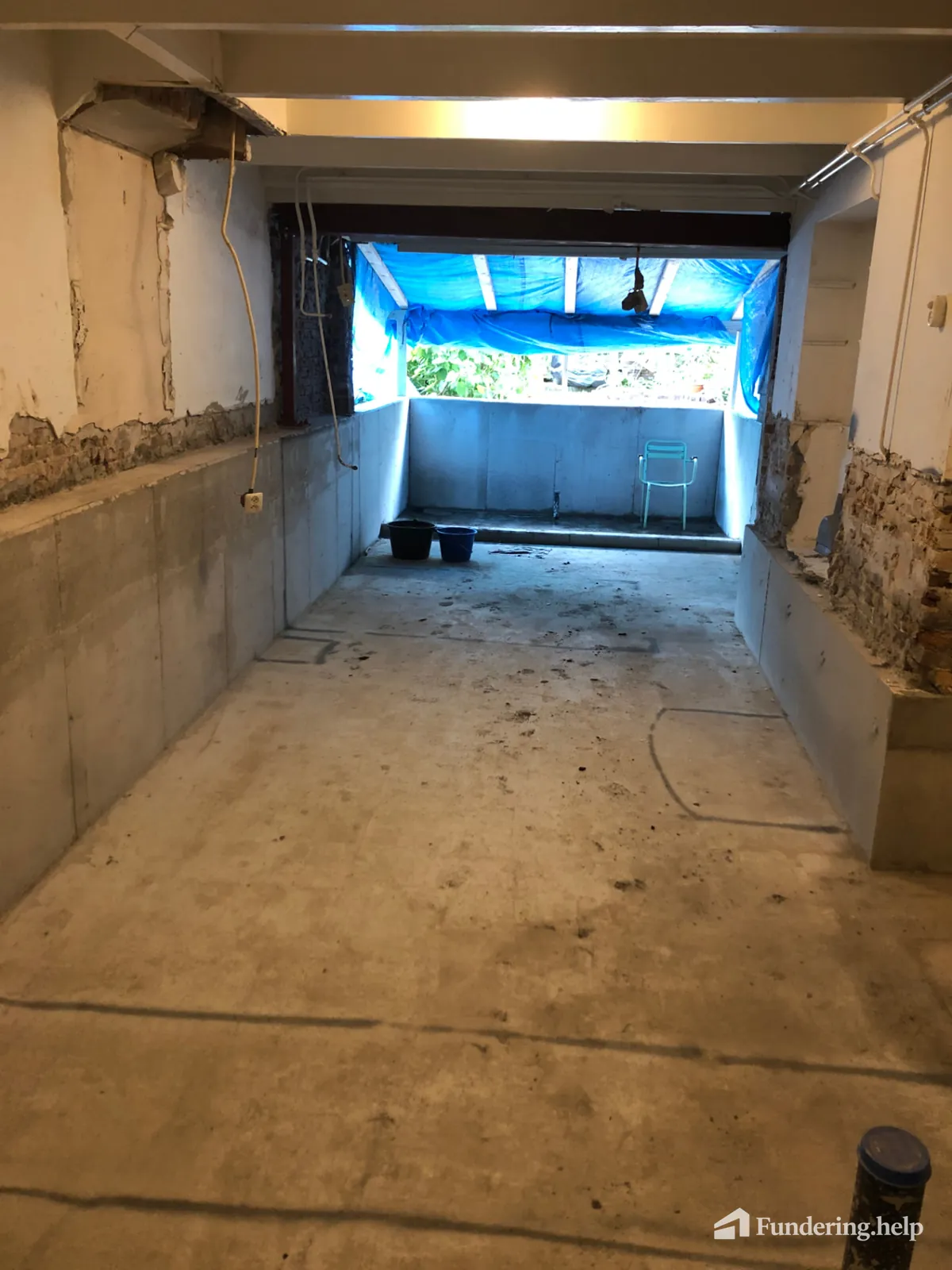 Afgewerkte betonnen kelderbak met nieuwe betonwanden onder een bestaande woning